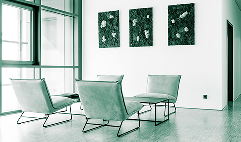 Moderner Besprechungsraum mit vier Sesseln, kleinem Tisch und dekorativen Bildern an der Wand.